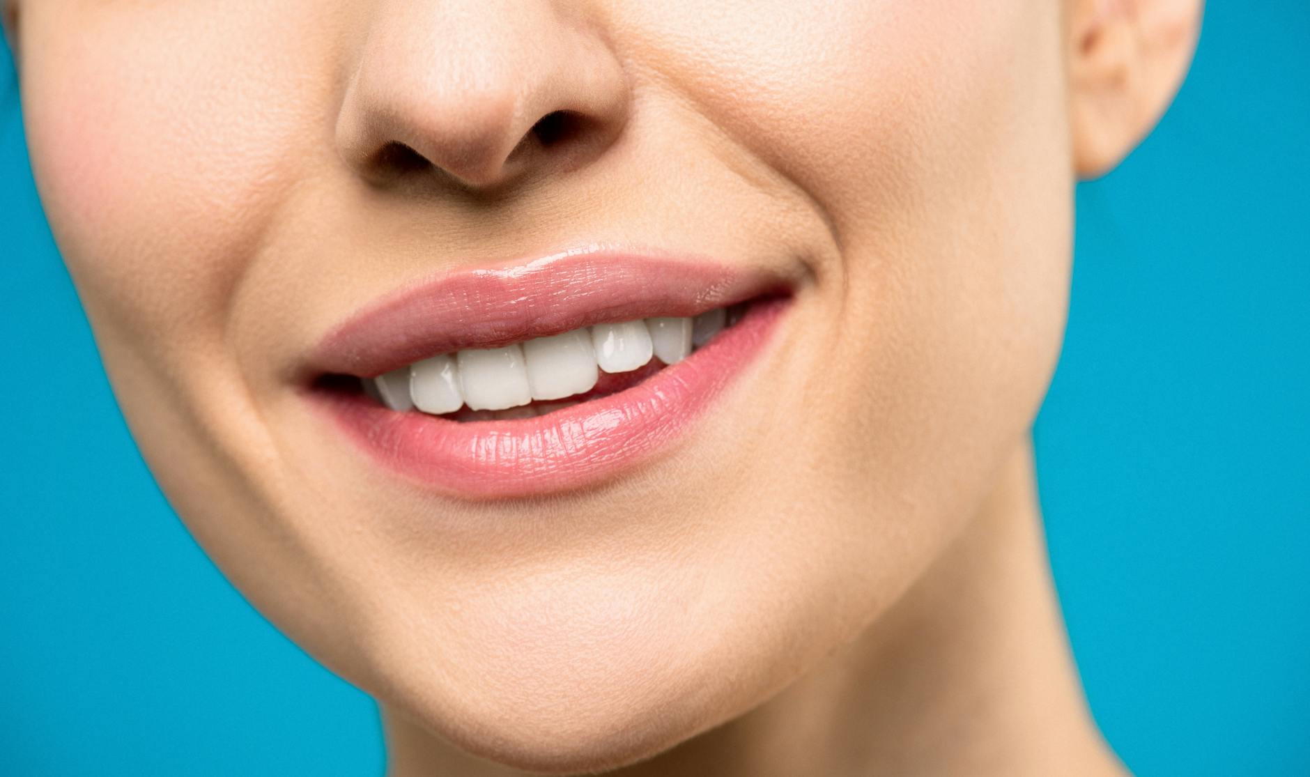 close up photo of woman with pink lipstick smiling